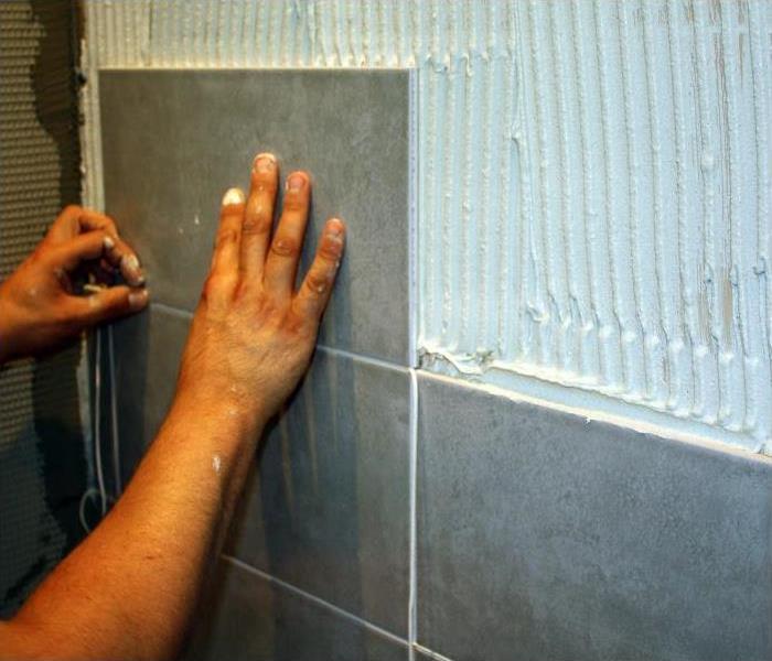 A SERVPRO professional putting new tile in a bathroom