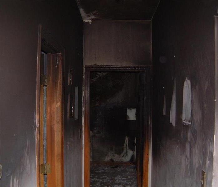 A hallway with soot and smoke damage on the walls.